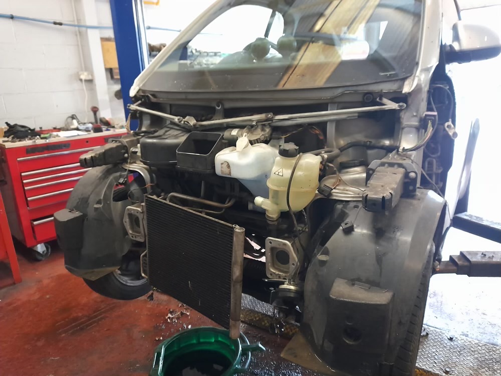 Close-up of the Smart car's front end during the cooling fan repair